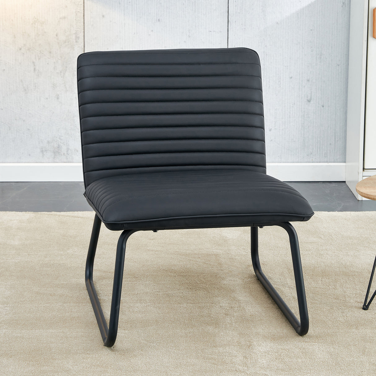 Black minimalist armless sofa chair with PU backrest paired with black metal legs