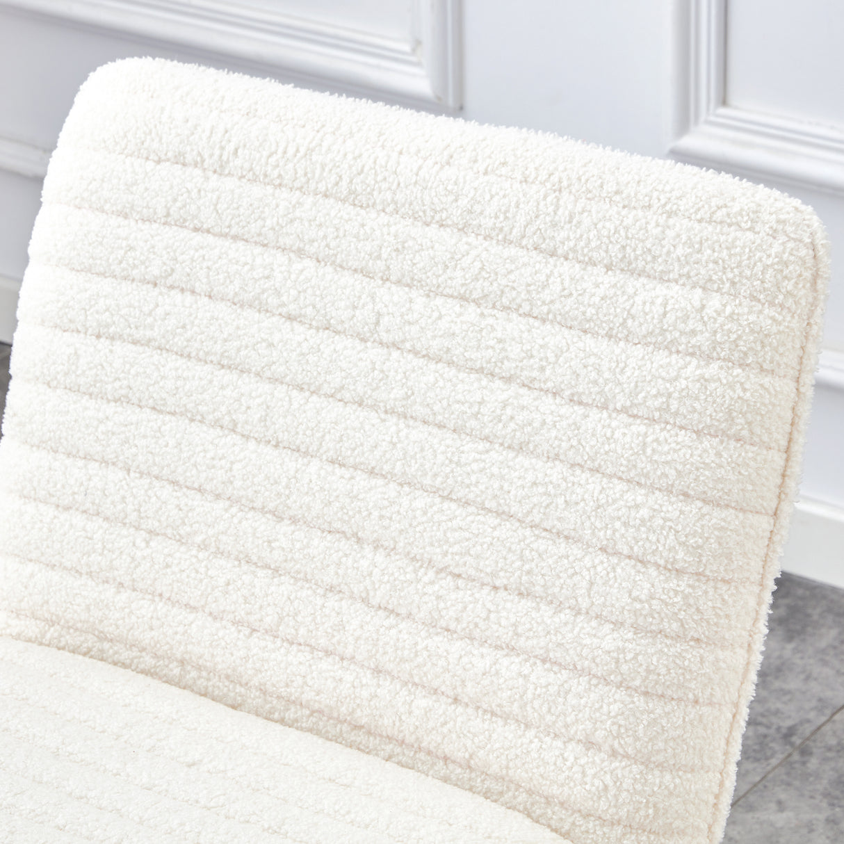 One White minimalist armless sofa chair with plush cushion and backrest paired with golden metal legs