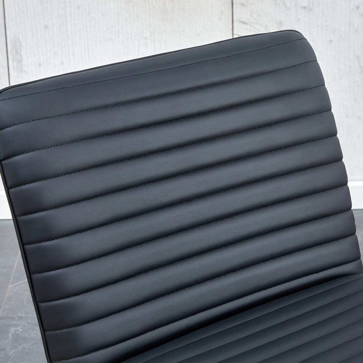 Black minimalist armless sofa chair with PU backrest paired with black metal legs